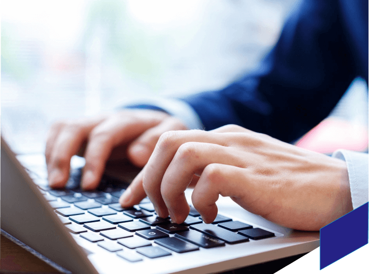 A person typing on a laptop keyboard.