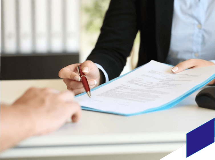 A person is signing papers at a table